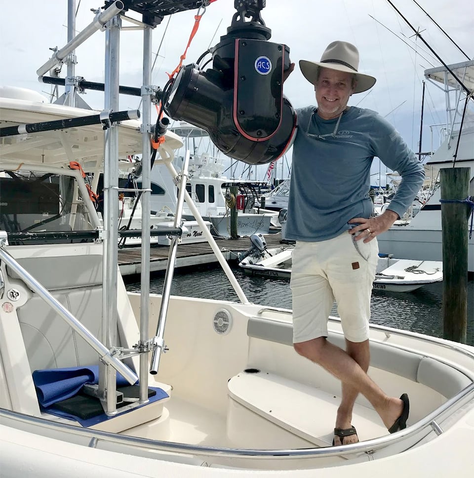 Marc Montocchio standing on bow of Pursuit rigged with high-speed camera. 