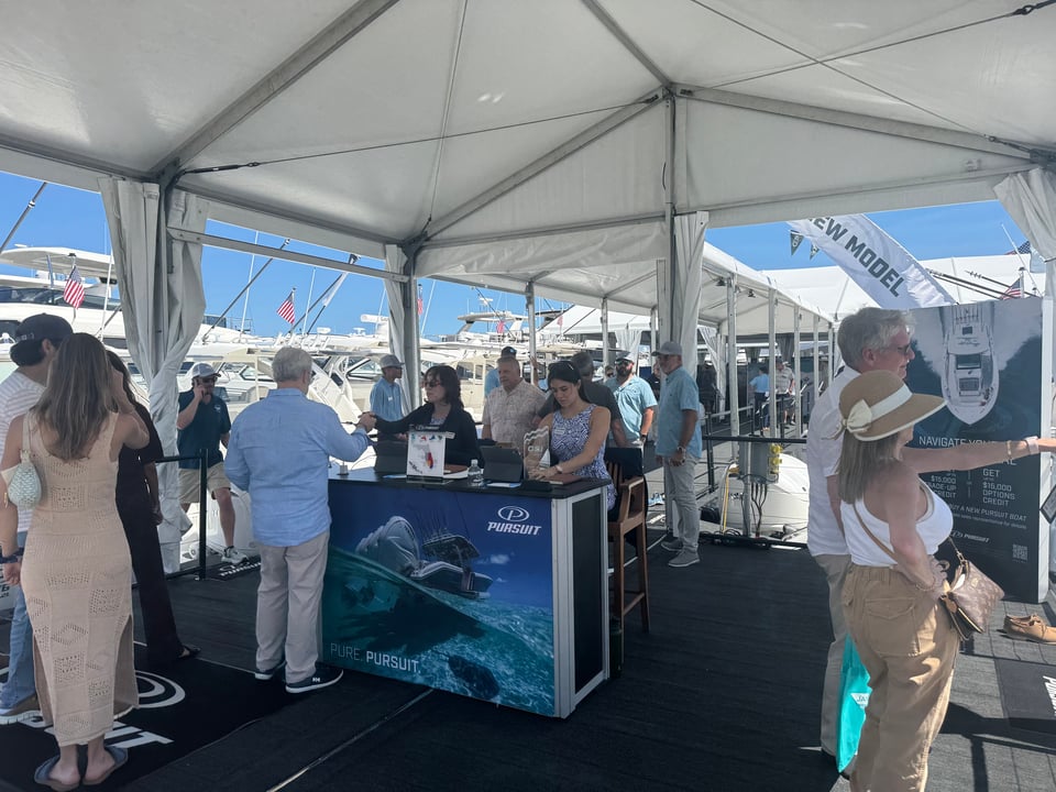 Greeters check in attendees at the Pursuit Boats booth at the Palm Beach International Boat Show