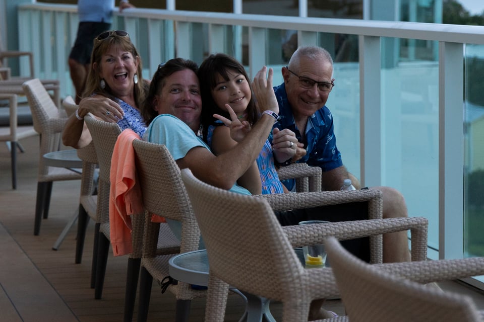 Milton, Debbie and their family sitting on a balcony