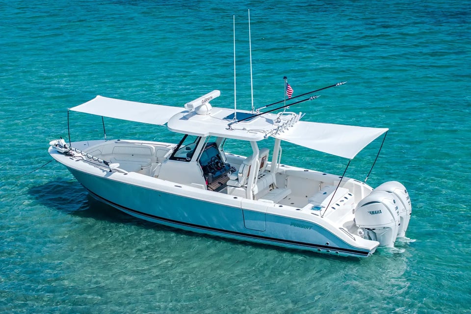 Pursuit S 288 center console boat with twin Yamaha outboards in clear blue water.