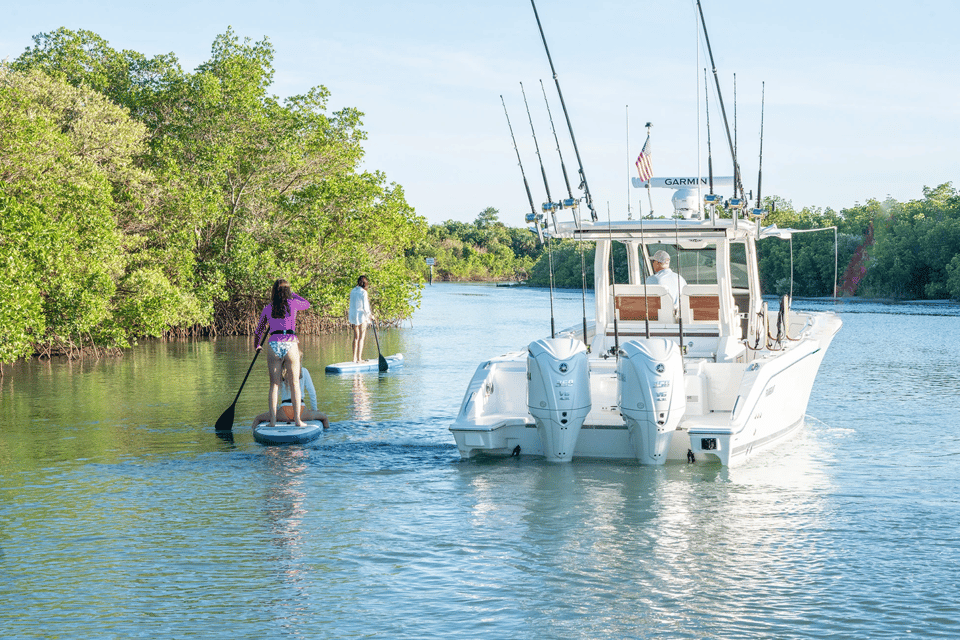 People paddle boarding aside a Pursuit S 328 