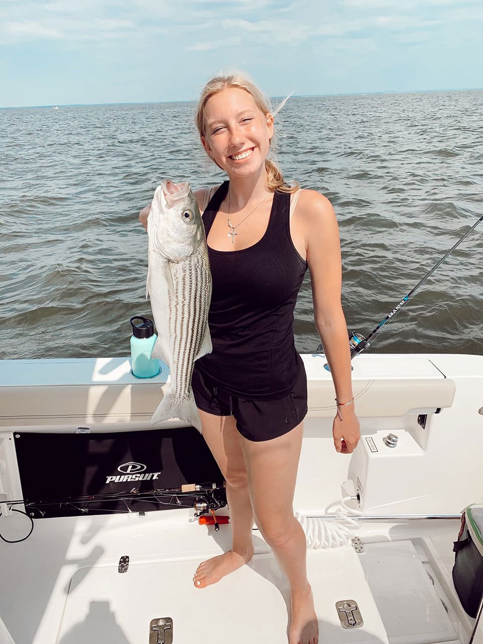 Girl hold fish on Pursuit S 288 boat