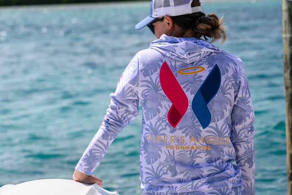 Woman with Piper's Foundation angel wing logo on shirt.