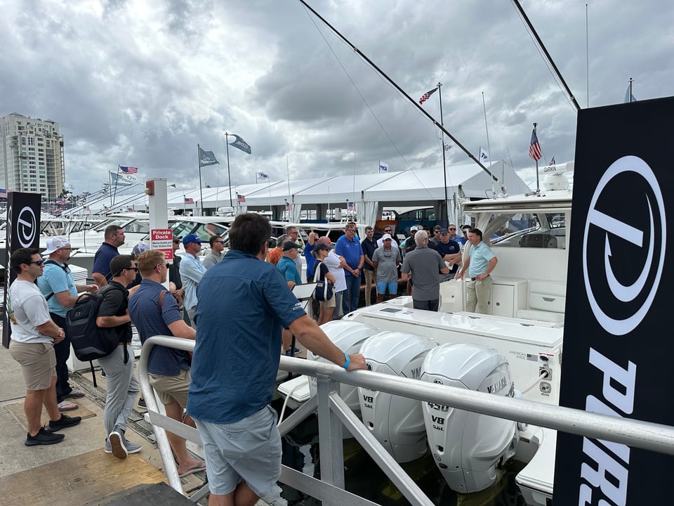 Crowd Gathers at Pursuit Booth with Staff