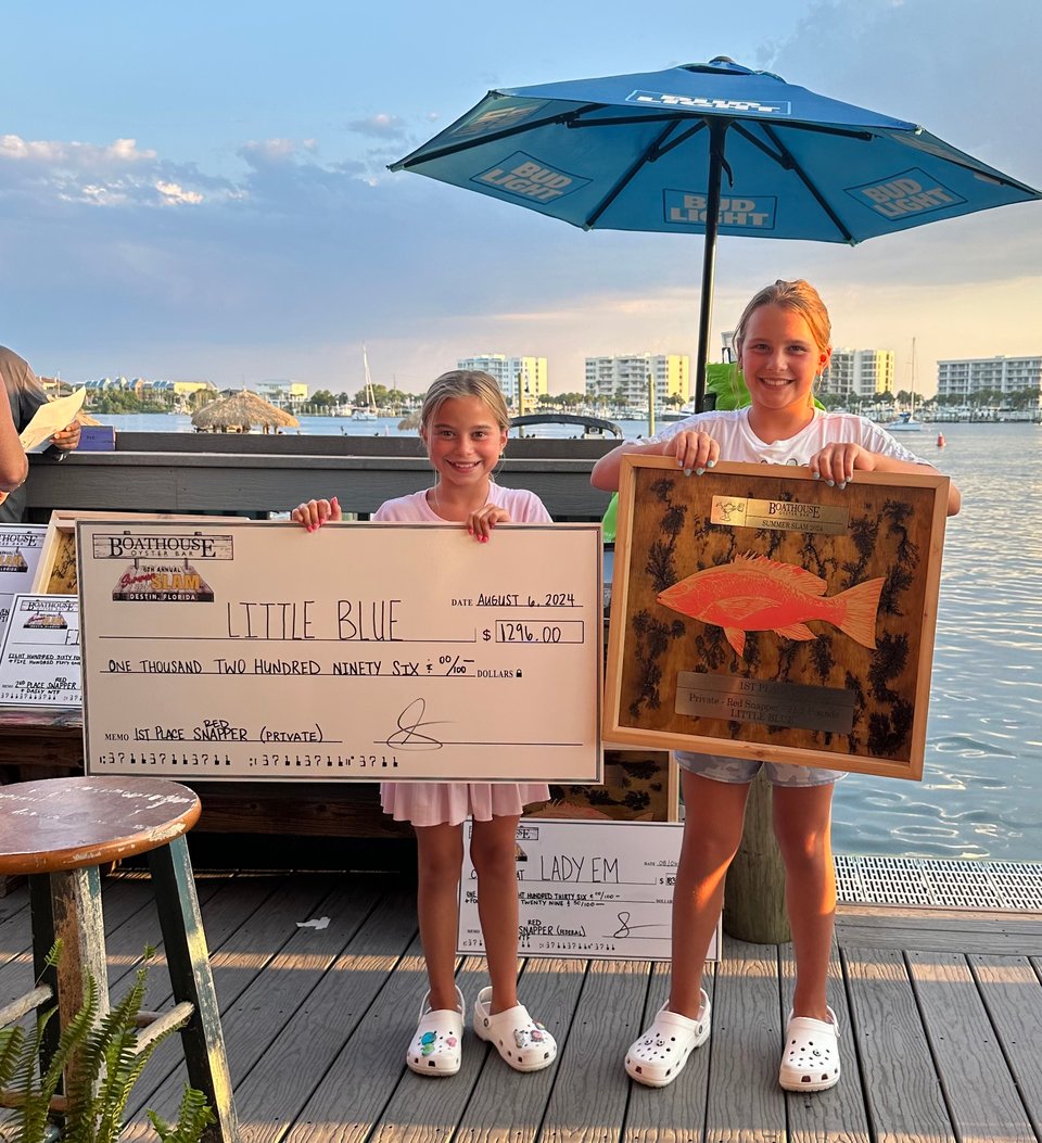 The twins hold prizes from a fishing tournament