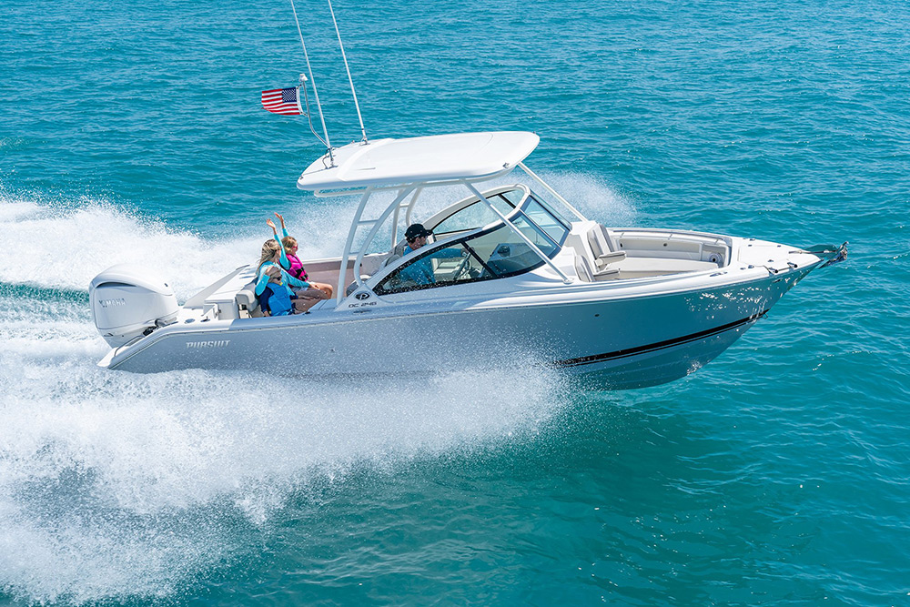 A starboard side exterior view of family fun on a DC 246 Pursuit Dual Console Boat running offshore.