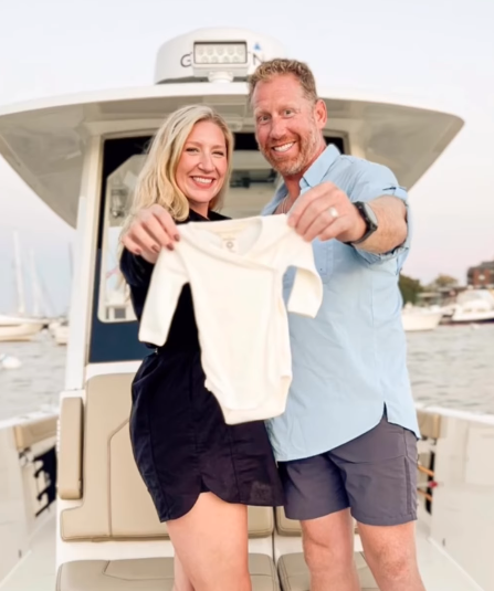 Husband and wife hold a onesie on their Pursuit Boat