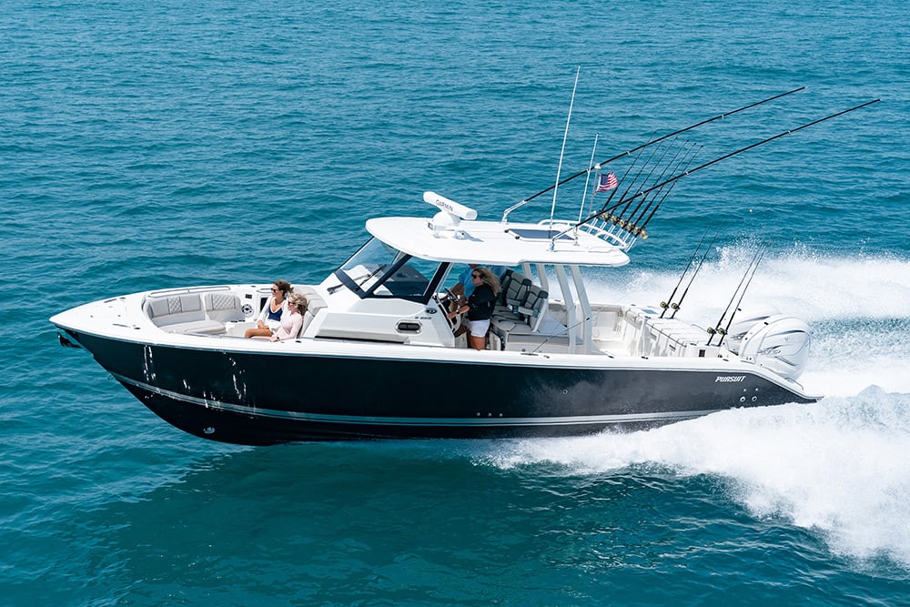 A woman at the helm of Pursuit Boats S 358 Sport Center Console Boat running offshore.