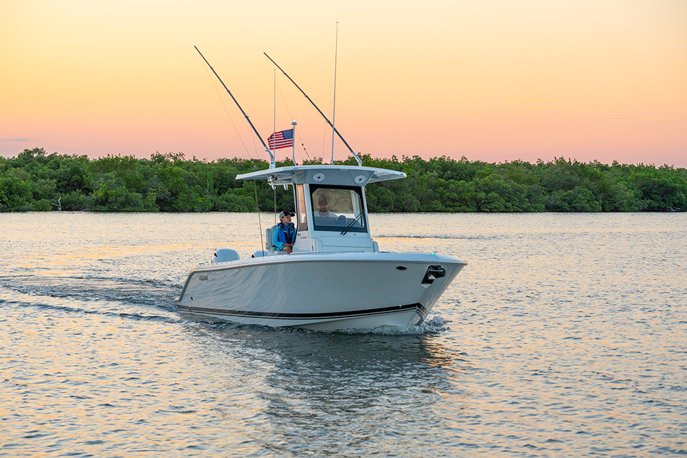 Front one quarter view of white S 268 Sport boat boat cruising right at sunset.